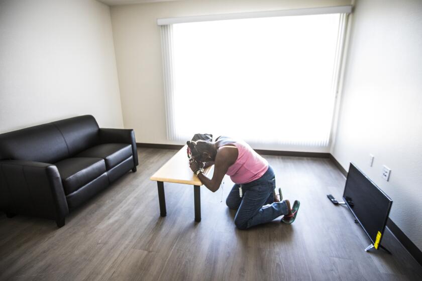 LOS ANGELES, CA SEPTEMBER 14, 2018: Yvette Grant known as Big Mama drops to her knees in prayer inside her apartment in Los Angeles, CA September 14, 2018. Today she received a key and can move out of her tent on the sidewalk into housing. (*Editors Note: Contact photo editor Mary Cooney should you have any questions. Please do not use this image for other stories. This image is for a future project by writer Tom Curwen.) (Francine Orr/ Los Angeles Times)