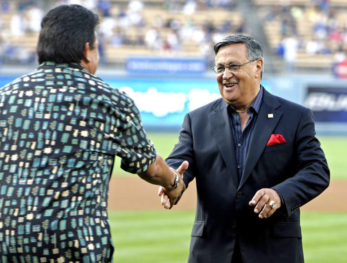 Jaime Jarrin shakes hands with former Dodgers pitcher Fernando Valenzuela during a ceremony in June 2008 honoring Jarrin for 50 years of broadcasting games for the franchise.