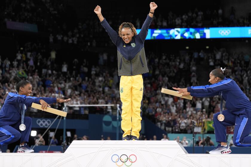 Silver medalist Simone Biles and bronze medalist Jordan Chiles bow as gold medalist Rebeca Andrade steps forward