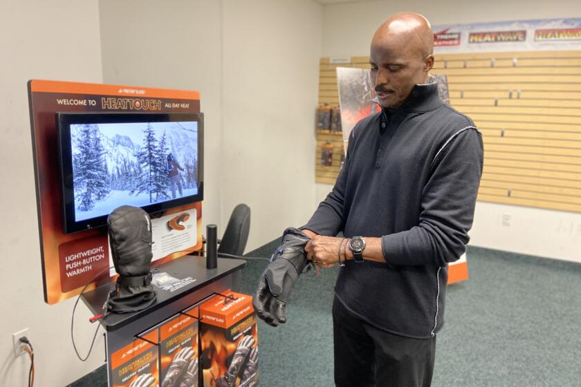 Mike Carey, a former NFL referee, is showing some products from his snowboarding apparel company in Poway, California. Company is called Seirus.