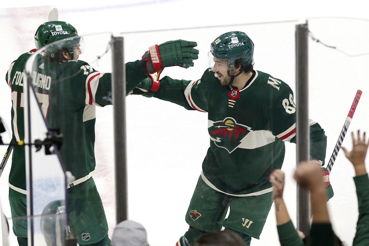 Minnesota Wild center Frederick Gaudreau (89) celebrates his winning goal against the Washington Capitals with left wing Marcus Foligno (17) during a shootout of an NHL hockey game Saturday, Jan. 8, 2022, in St, Paul, Minn. (AP Photo/Andy Clayton-King)