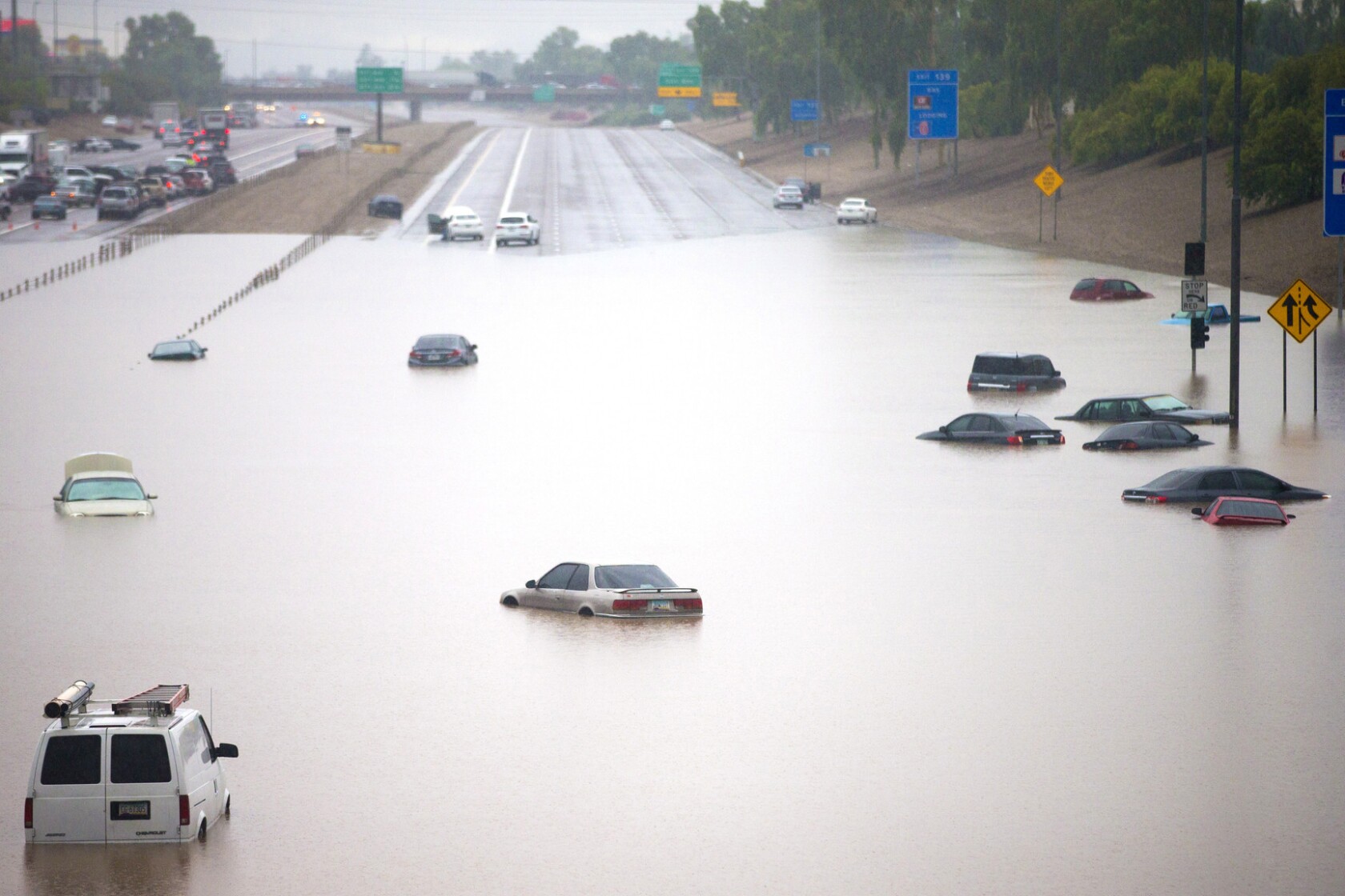Woman dies in submerged car in record Arizona rain, widespread floods
