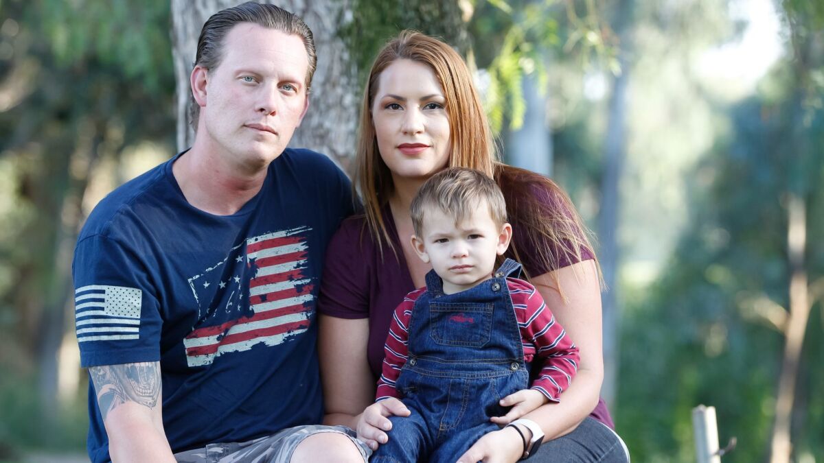 Ron and Janalee Roper sit with their son Jett, 21 months, on Tuesday at Kit Carson park in Escondido, California.