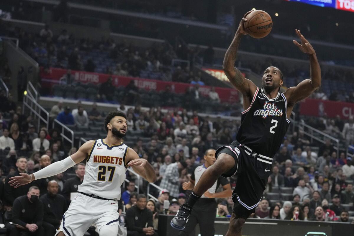 Kawhi Leonard (2), de los Clippers de Los Ángeles, anota ante la mirada de su rival de los Nuggets