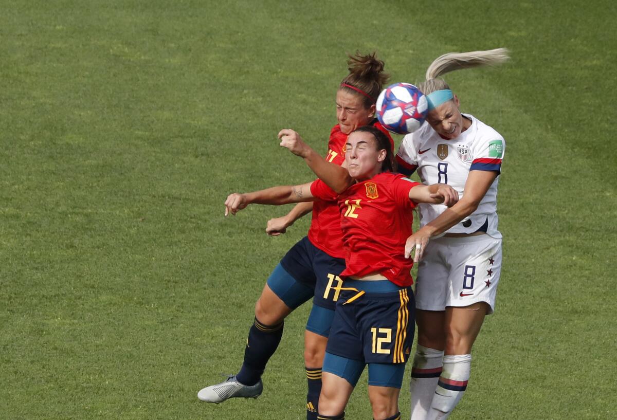 Julie Ertz of the U.S., right, jumps for the ball with Spain's Patri Guijarro, center, and Lucia Garcia.