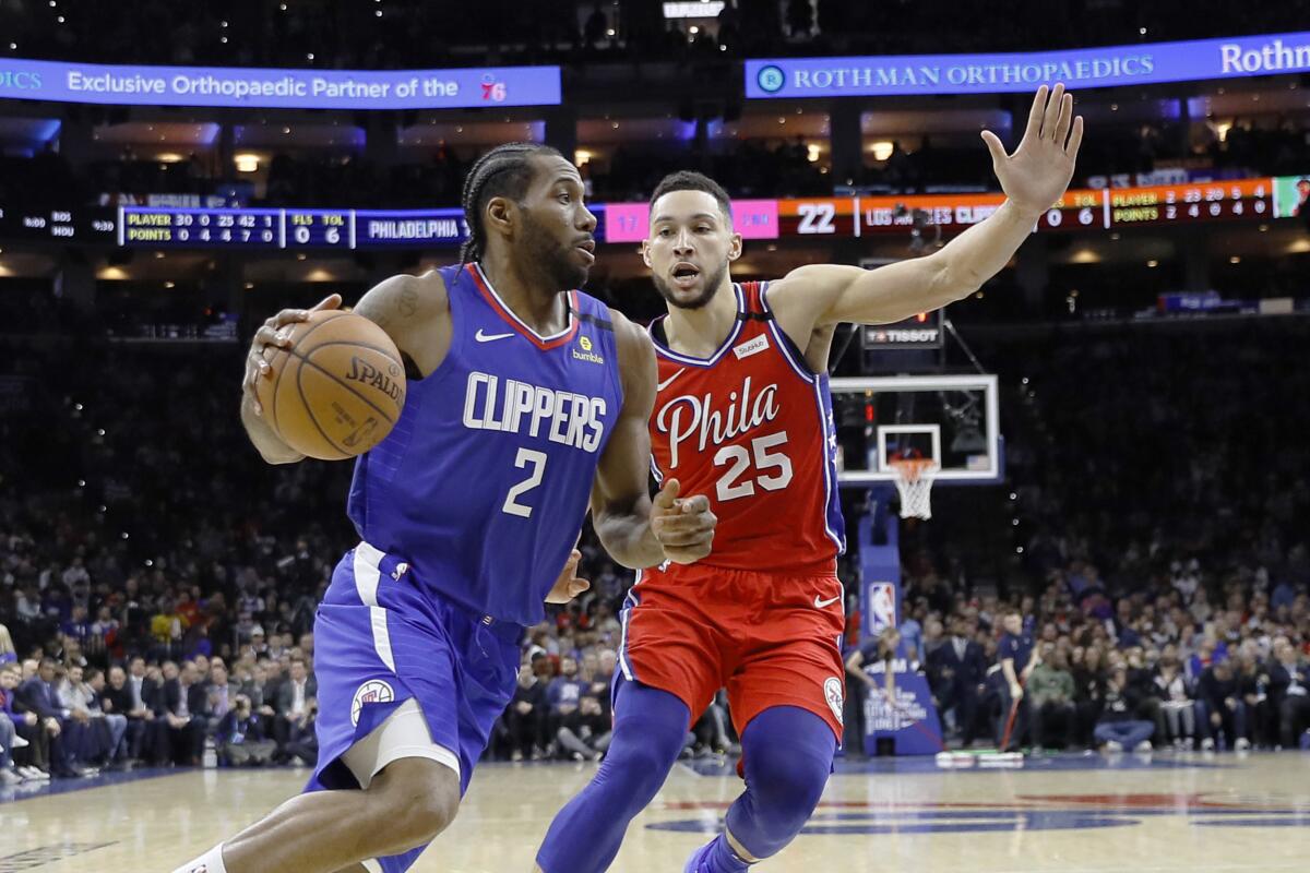 The Clippers' Kawhi Leonard drives past Philadelphia's Ben Simmons during the first half Tuesday in Philadelphia.