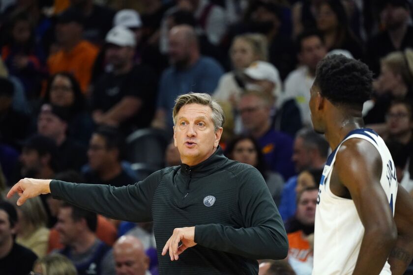 Minnesota Timberwolves head coach Chris Finch, left, talks with Timberwolves guard Anthony Edwards, right, during the second half of an NBA basketball game against the Phoenix Suns Wednesday, March 29, 2023, in Phoenix. The Suns won 107-100. (AP Photo/Ross D. Franklin)