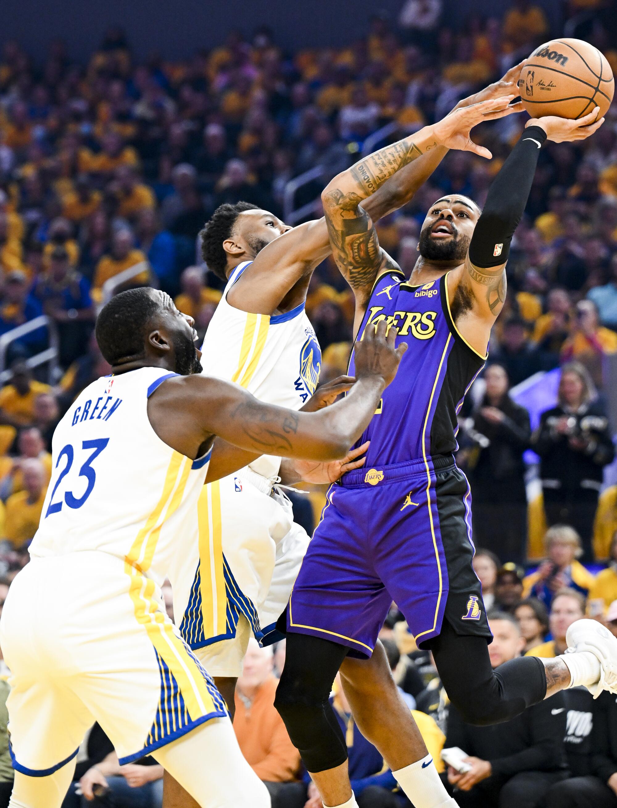 Lakers guard D'Angelo Russell goes up for a shot while pressured by Warriors forward Andrew Wiggins during the first half.