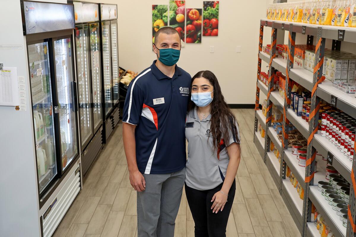 Associated Students Inc. President Josh Mitchell and Board Chair Mary Chammas inside the food pantry.