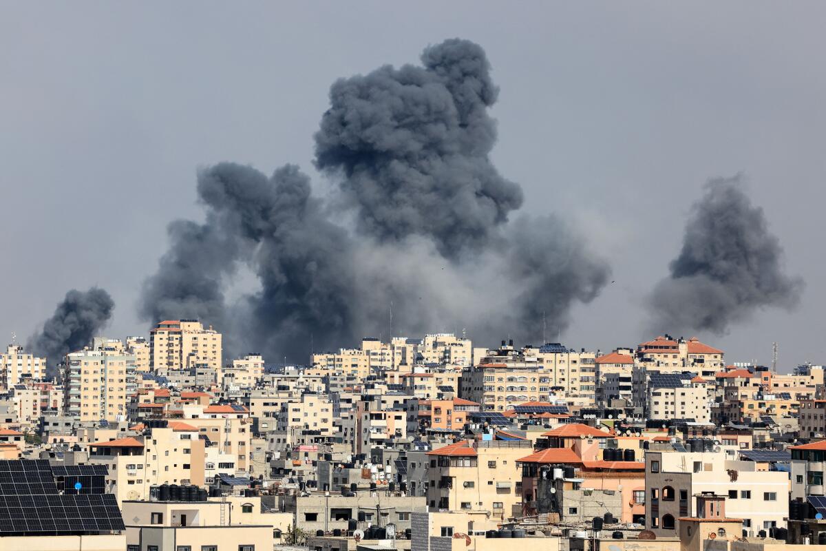 Smoke rises over buildings during air strikes.