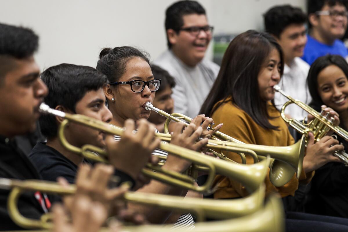 Students play trumpets in class.