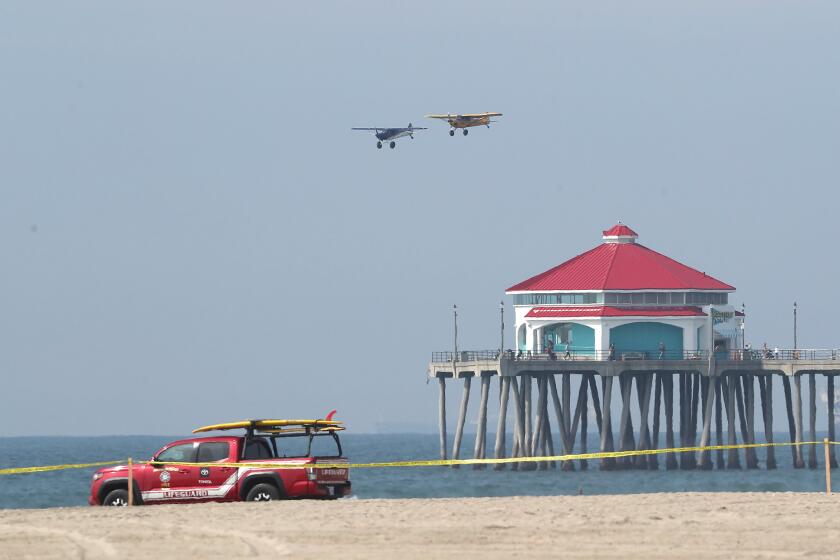 Two featured Short Landing and Take-off aircraft better known as a STOL plane, makes a pass over the pier during the Pacific Airshow press conference on the beach at the end of Huntington St. in Huntington Beach on Thursday. The STOL is popular with Alaska bush pilots because of their ability to land on short runways or water with minimal effort. The planes will be featured in the 2024 Pacific Air Show. This year, the Pacific Airshow will build a temporary runway on the sand for touch and go landings to entertain the crowd.