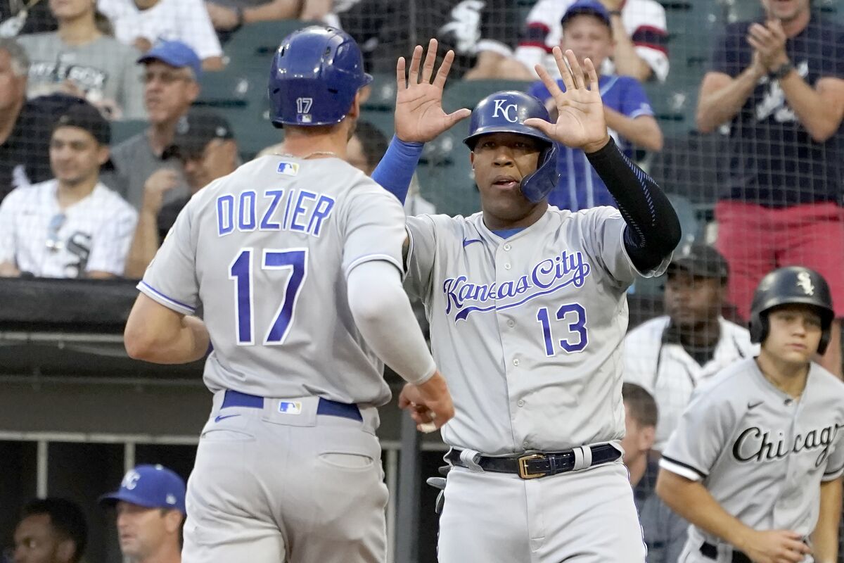 Kansas City Royals' Salvador Perez (13) greets Hunter Dozier at home after they scored on Emmanuel Rivera's double during the first inning of a baseball game against the Chicago White Sox Thursday, Aug. 5, 2021, in Chicago. (AP Photo/Charles Rex Arbogast)