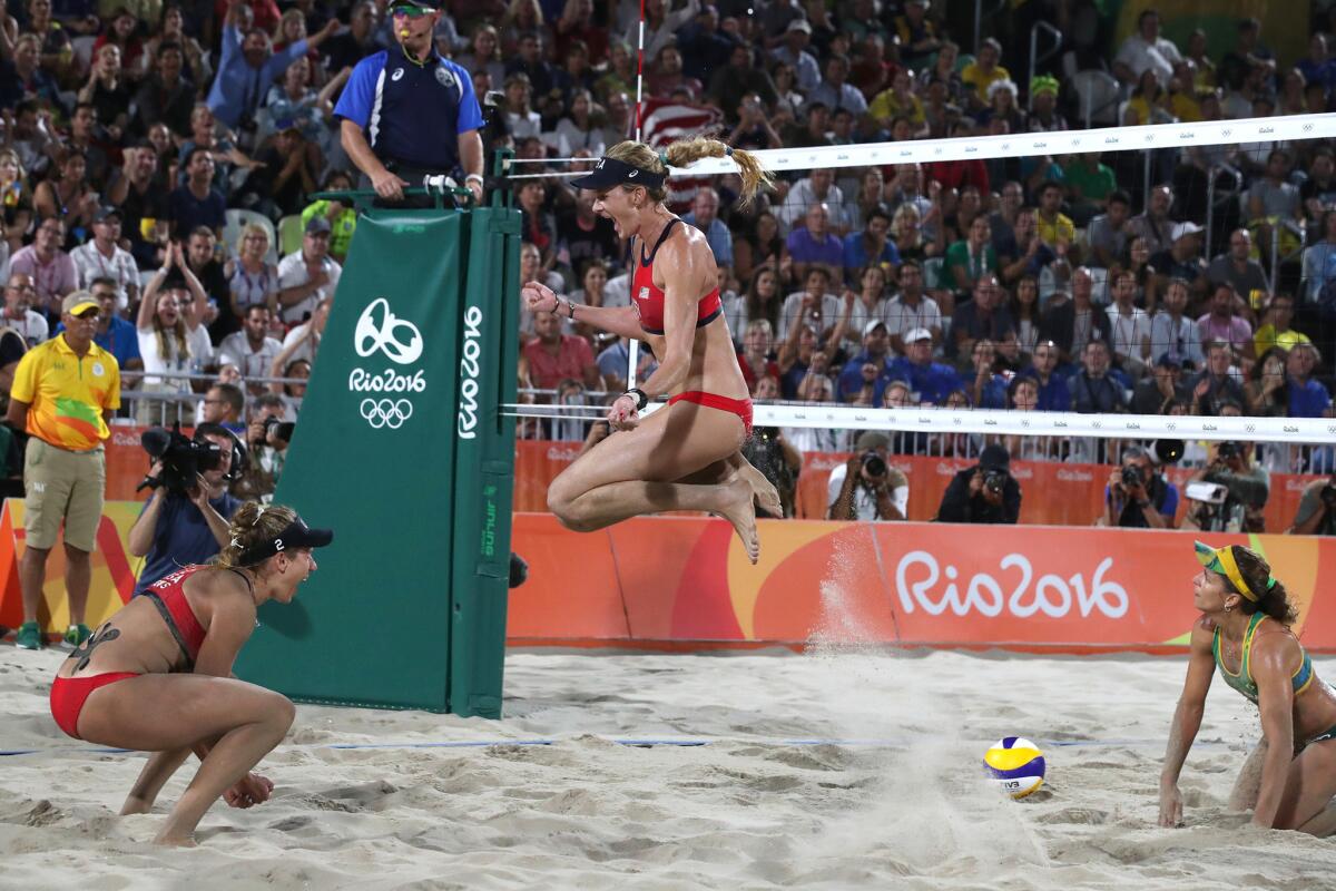 April Ross, left, and Kerry Walsh Jennings celebrate the moment they beat the Brazil team of Larissa Franca Maestrini and Talita Rocha for the women's beach volleyball bronze medal.