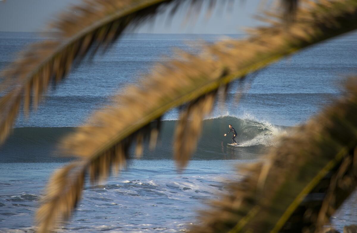 A surfer rides a big wave near the pier in San Clemente. The San Clemente Pier was one of two Orange County beaches to make the Beach Bummer list this year.