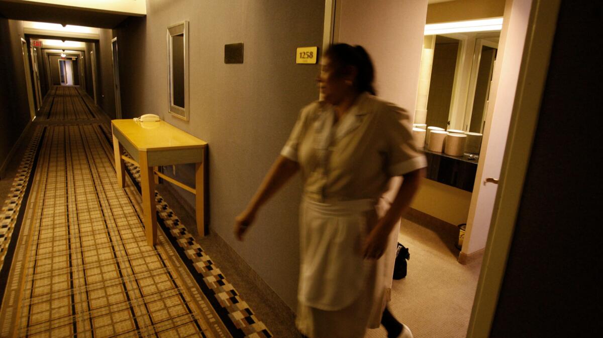 Maria Jimenez, a housekeeper, closes a door on the 12th floor of the Wilshire Grand Hotel in downtown Los Angeles in 2011. A survey commissioned by the travel site Expedia finds that Americans are split on tipping hotel staff.
