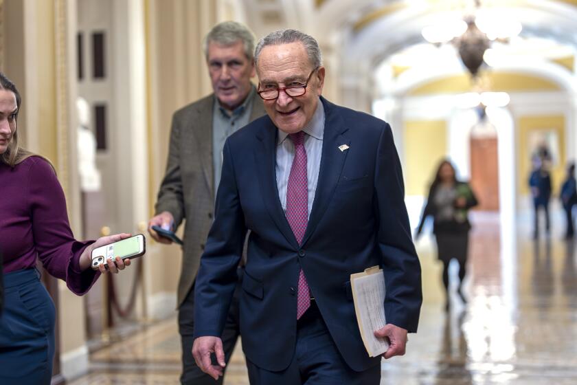 Senate Majority Leader Chuck Schumer, D-N.Y., walks outside the chamber as he tries to assemble enough lawmakers to begin the final steps of completing a partial government funding bill, at the Capitol in Washington, Friday, March 8, 2024. (AP Photo/J. Scott Applewhite)
