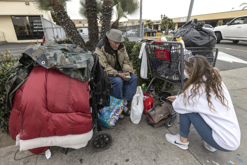 SAN DIEGO, CA - JANUARY 31, 2022: Amie Zamudio, Director of Homeless Outreach for Housing 4 Homeless, talks to Steven Lawshe, 63, who says he grew up in San Diego and is now homeless, as she tries to help him on Sports Arena Boulevard in San Diego on Monday, January 31, 2022. Zamudio said she was going to get Lawshe a hotel room, paid for by Housing 4 Homeless, for the night. (Hayne Palmour IV / For The San Diego Union-Tribune)