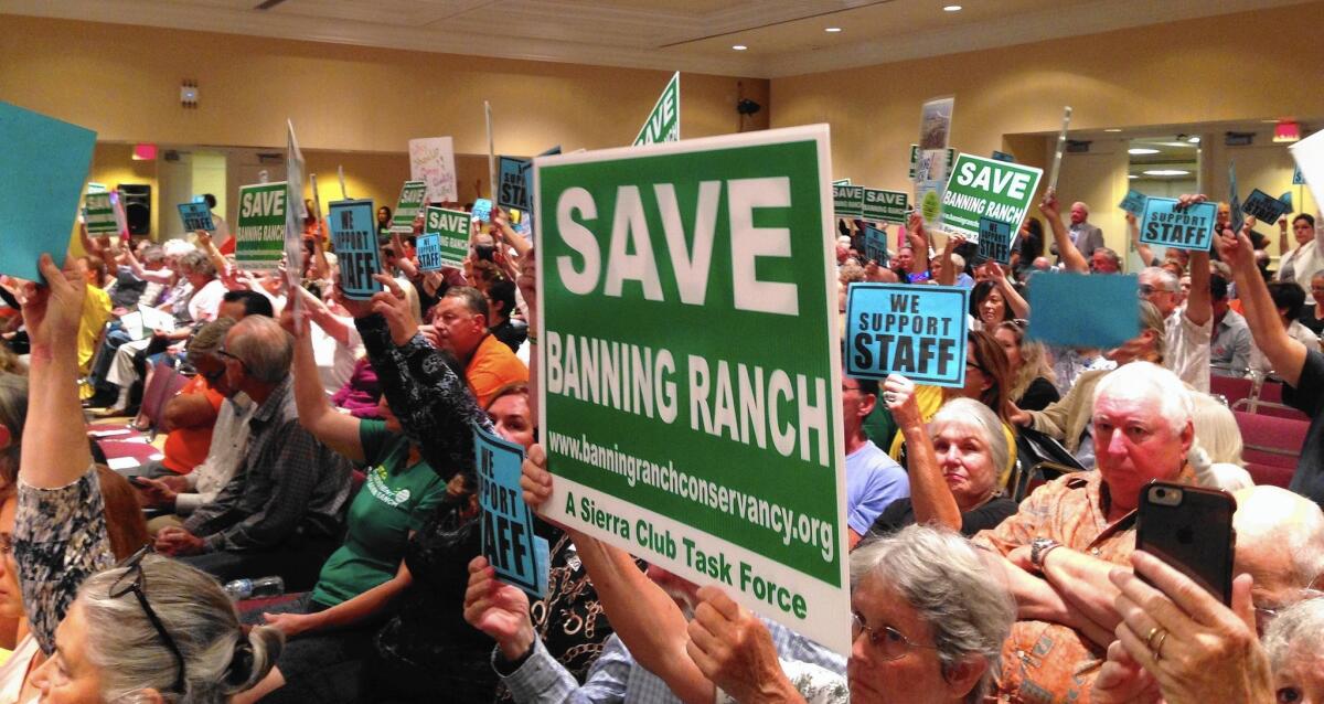 Members of the Banning Ranch Conservancy from Newport Beach, Costa Mesa and Huntington Beach raise signs in support of the California Coastal Commission staff recommendation that the commission deny the Banning Ranch project.