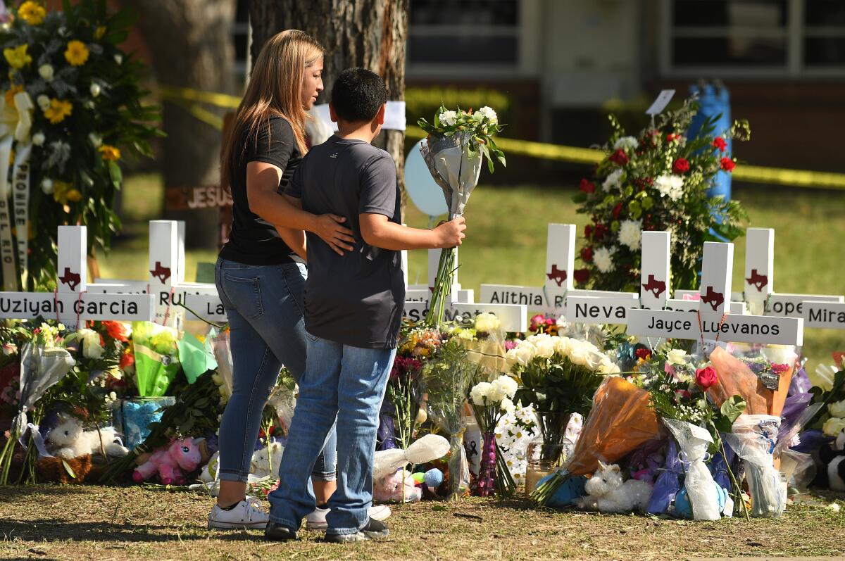 Family members place flowers at a memorial outside Robb Elementary School in Uvalde, Texas.