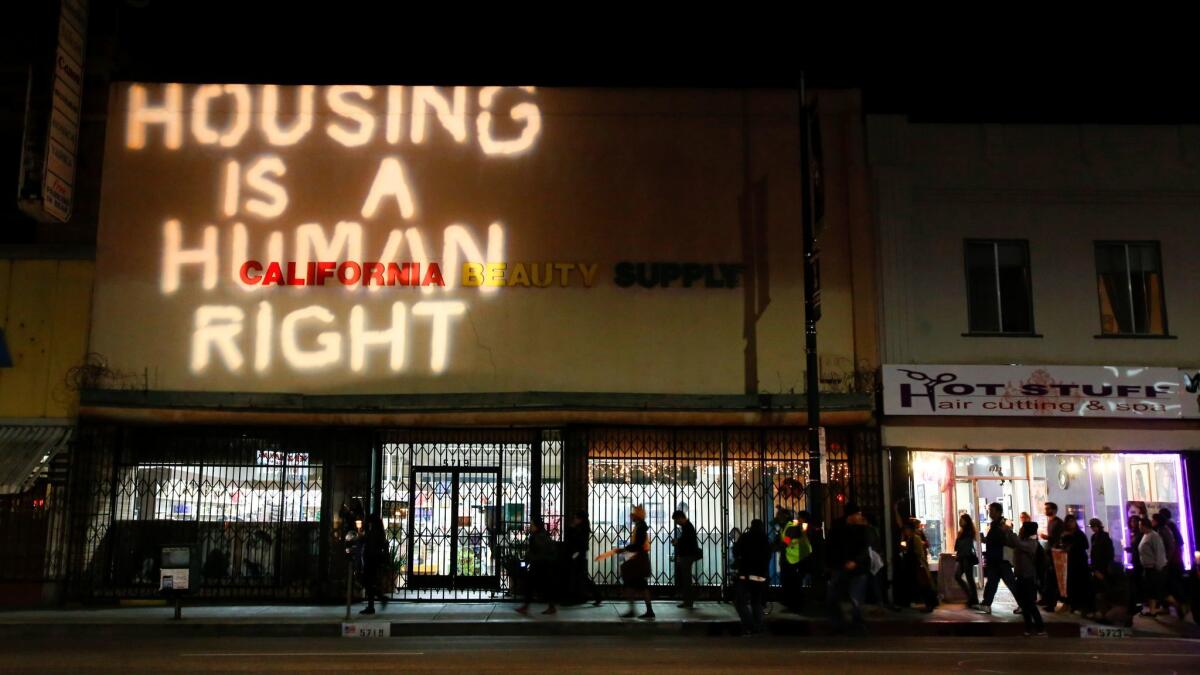 A phrase of protest is projected onto a building during a 2014 event against evictions in Highland Park. L.A. City Councilman Gil Cedillo, who is running for reelection, has been criticized by constituents who say he's not doing enough to stop displacement of renters.