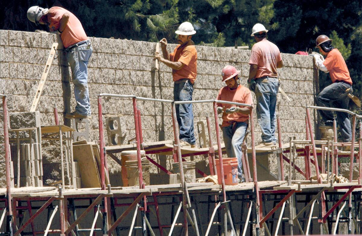 Construction workers put up a sound wall along the 134 freeway and Kenwood Pl. on Thursday, July 19, 2007.