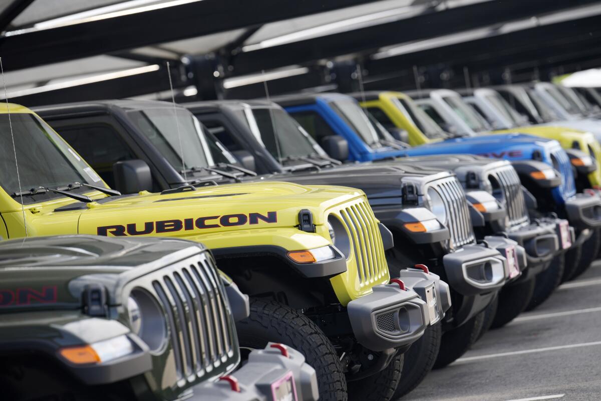 Jeep Gladiator pickup trucks sit in a long row at a dealership