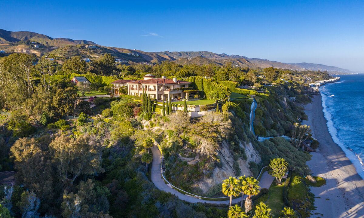 The 3.5-acre spread includes a main house, two guesthouses, a tennis court and a private path to the beach.