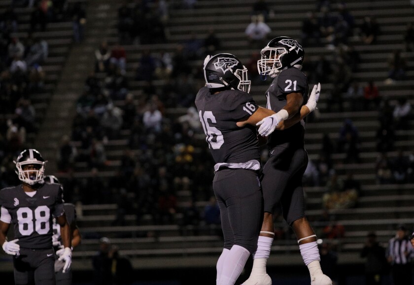 St. John Bosco running back Rayshon Luke (21) celebrates a touchdown with teammate Adam Awaida (16).