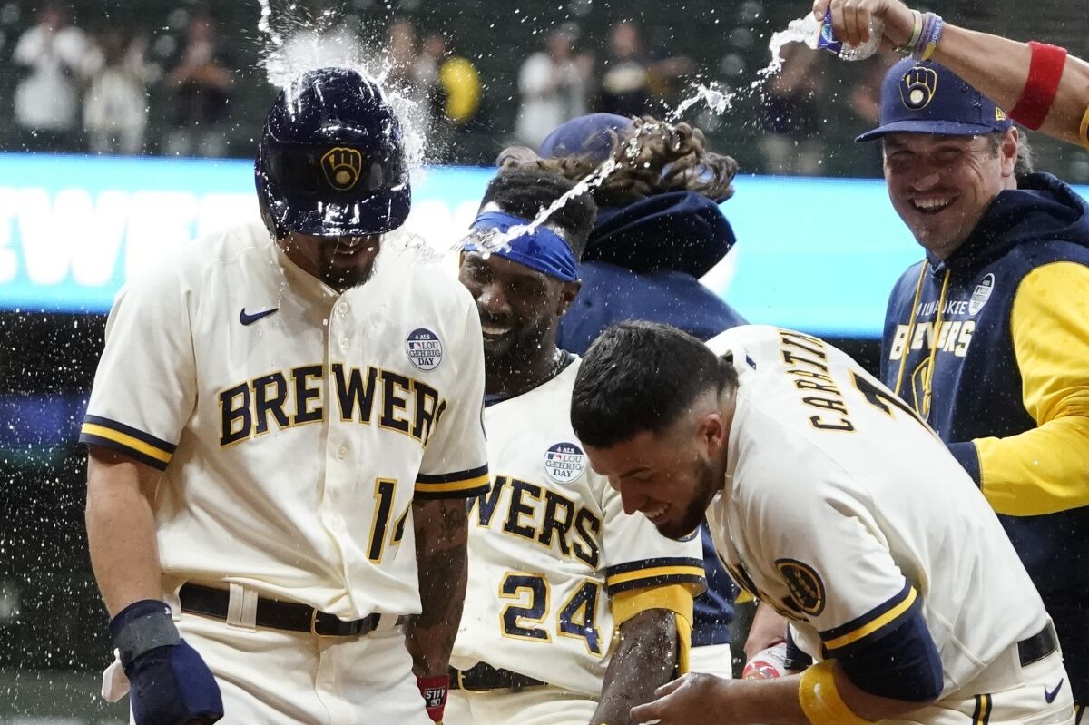 Brewers' Jace Peterson (14), Andrew McCutchen (24) and Victor Caratini celebrate.