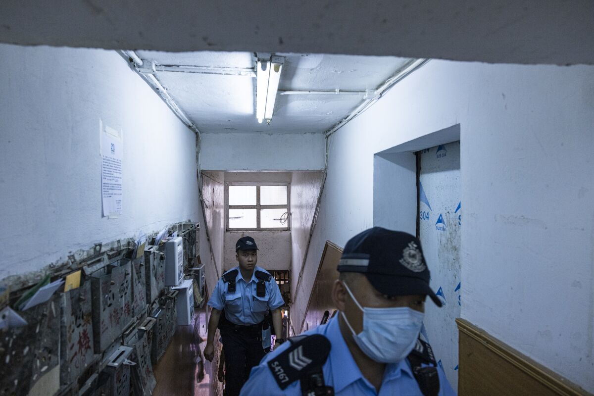 Police officers walk up an apartment where three children were killed in Sham Shui Po in Hong Kong, Monday, June 5, 2023. Hong Kong police arrested a woman accused of killing her three young daughters on Monday in a case that has shocked many in the city, where violent crime is rare. (AP Photo/Louise Delmotte)