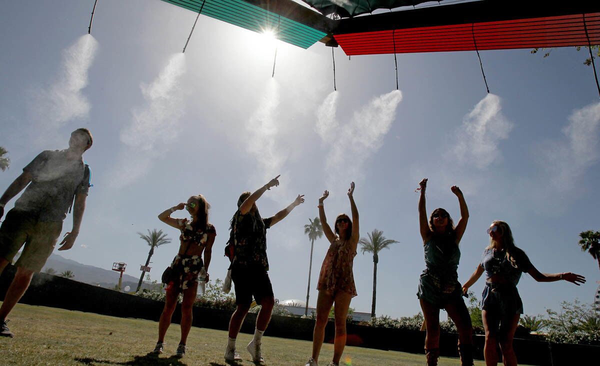 INDIO, CALIF. - APRIL 15, 2017. Festival goers cool off under misters at the Do Lab on day two of the Coachella Music and Arts Festival in Indio on Saturday, April 15, 2017. (Luis Sinco/Los Angeles Times)