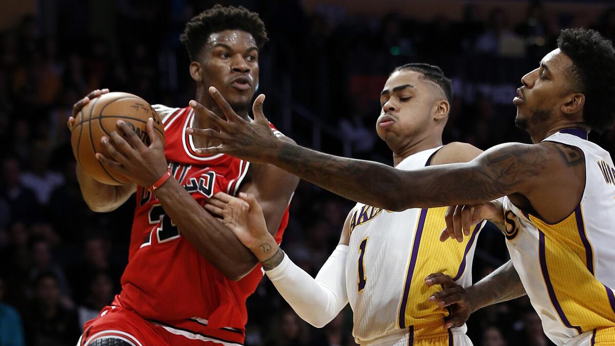 Bulls forward Jimmy Butler looks to pass after his baseline drive was cut off by Lakers guards D'Angelo Russell (1) and Nick Young during the first half.