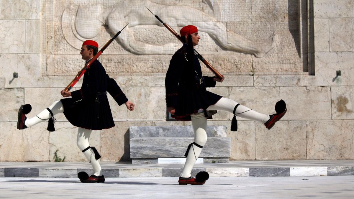 Greek guards march at the monument of the unknown soldier in front of the parliament in Athens.