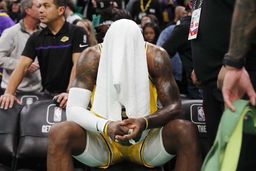 Los Angeles Lakers' LeBron James sits on the bench during overtime in the team's NBA basketball game against the Boston Celtics, Saturday, Jan. 28, 2023, in Boston. (AP Photo/Michael Dwyer)