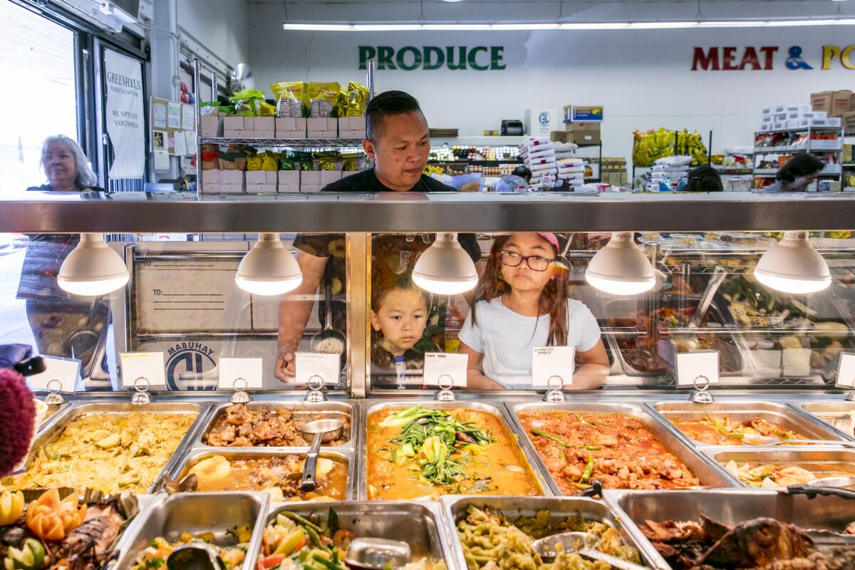 A father and his children eye the variety of turo turo options at Greenhills Market & Fast Food