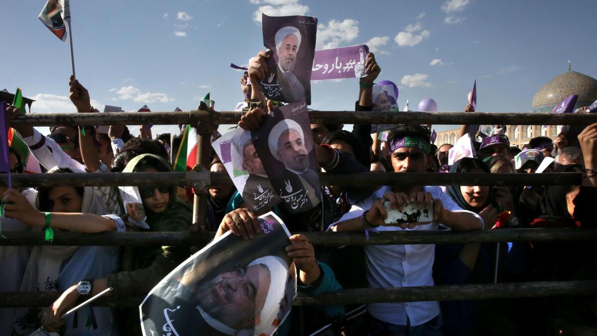 Supporters of Iranian President Hassan Rouhani hold signs at a pre-election rally in Isfahan, Iran.