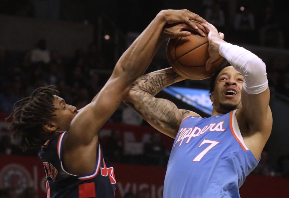 Clippers forward Amir Coffey fights for control of the ball against 76ers guard Tyrese Maxey.
