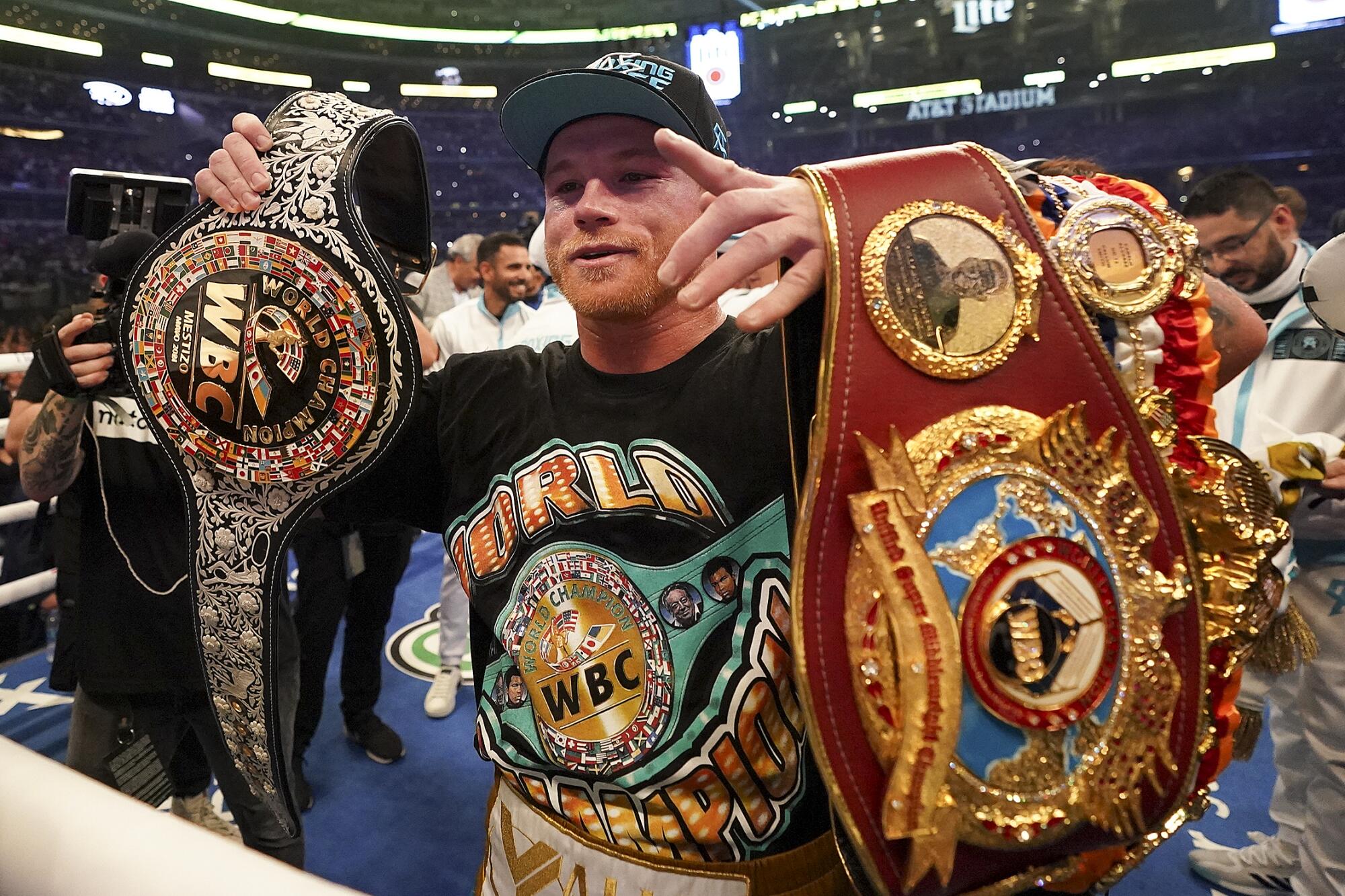 Canelo Álvarez celebrates with title belts after defeating Billy Joe Saunders.