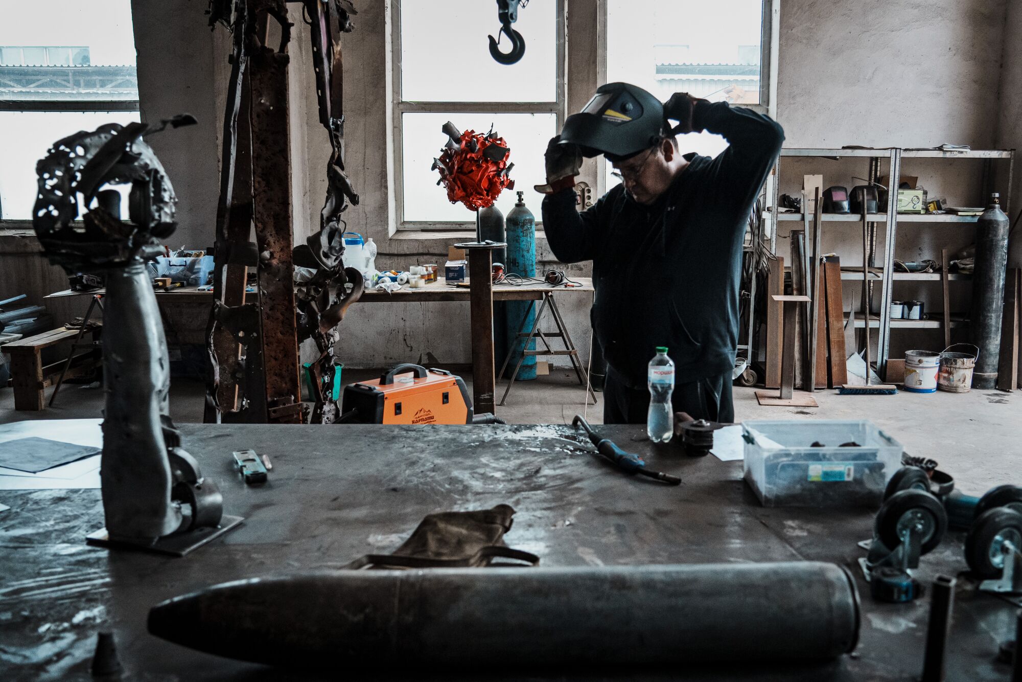 A man puts on a welding mask in a studio 