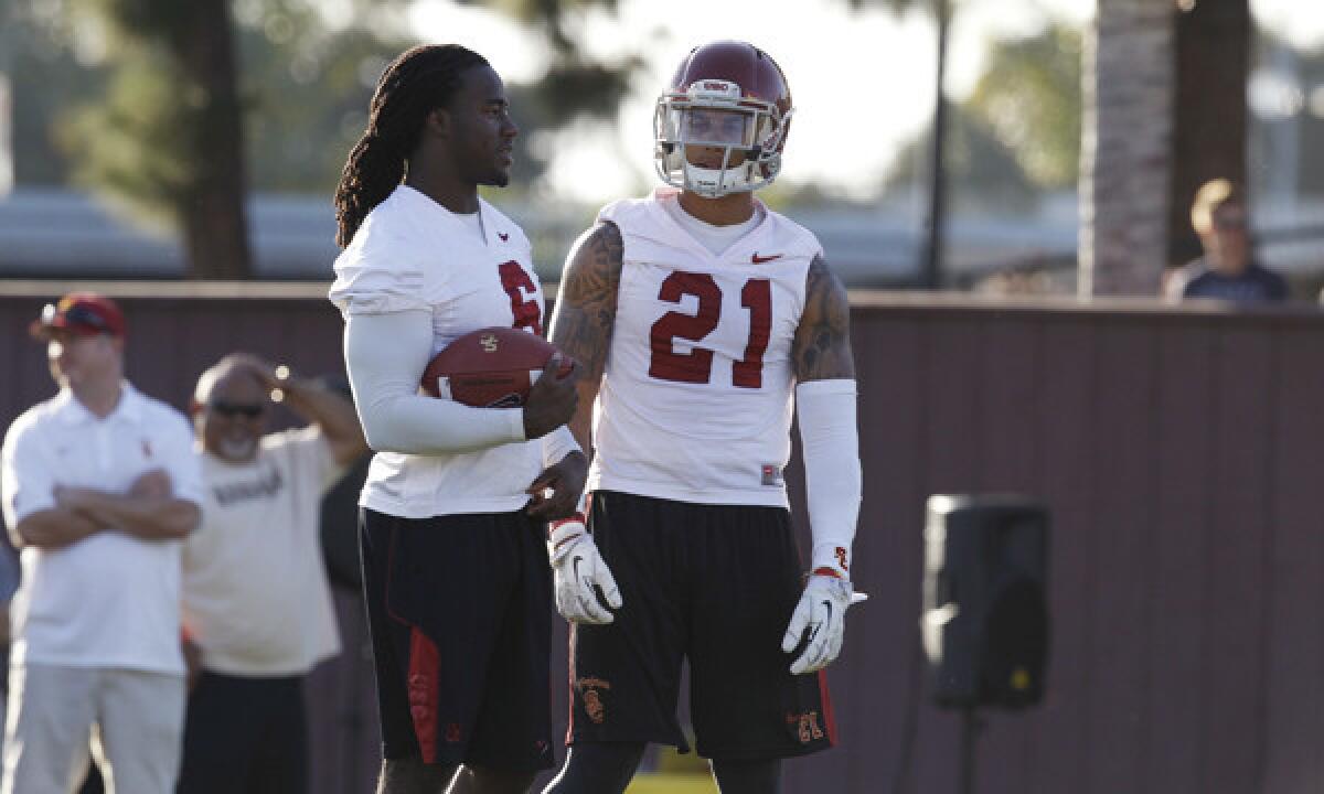 USC's Josh Shaw, left, and Su'a Cravens talk during a spring practice session on March 13.