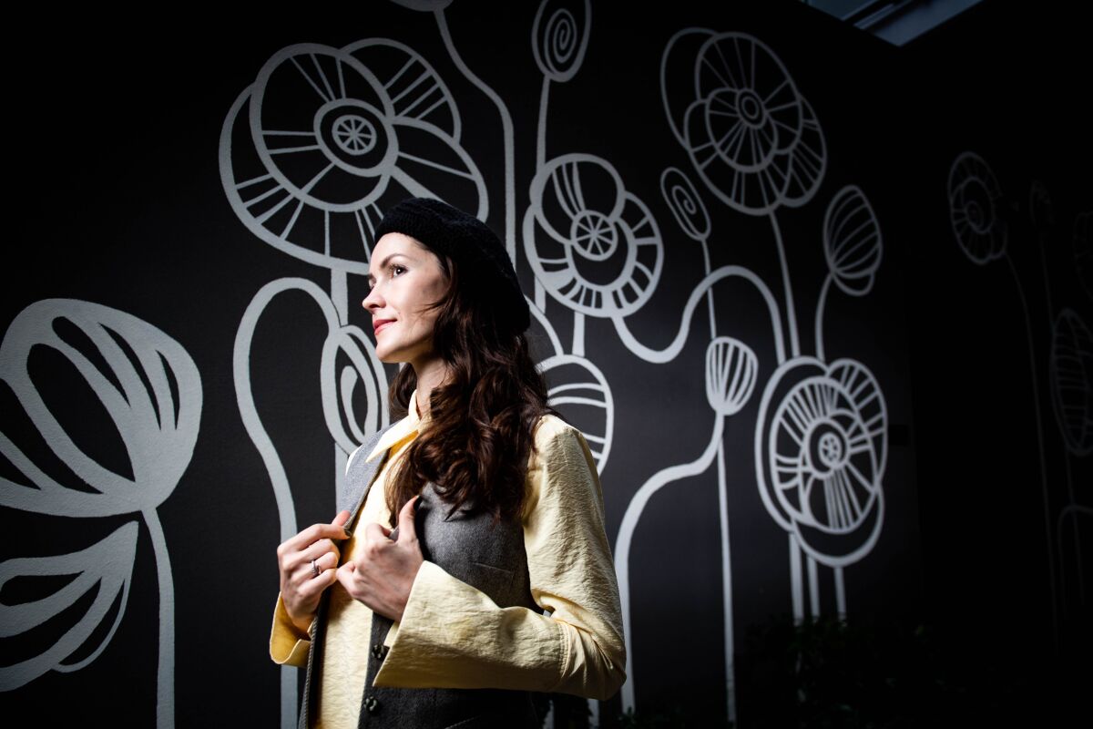 Anna Pearson, a Ukrainian-born artist, poses near a mural she painted outside the North City development