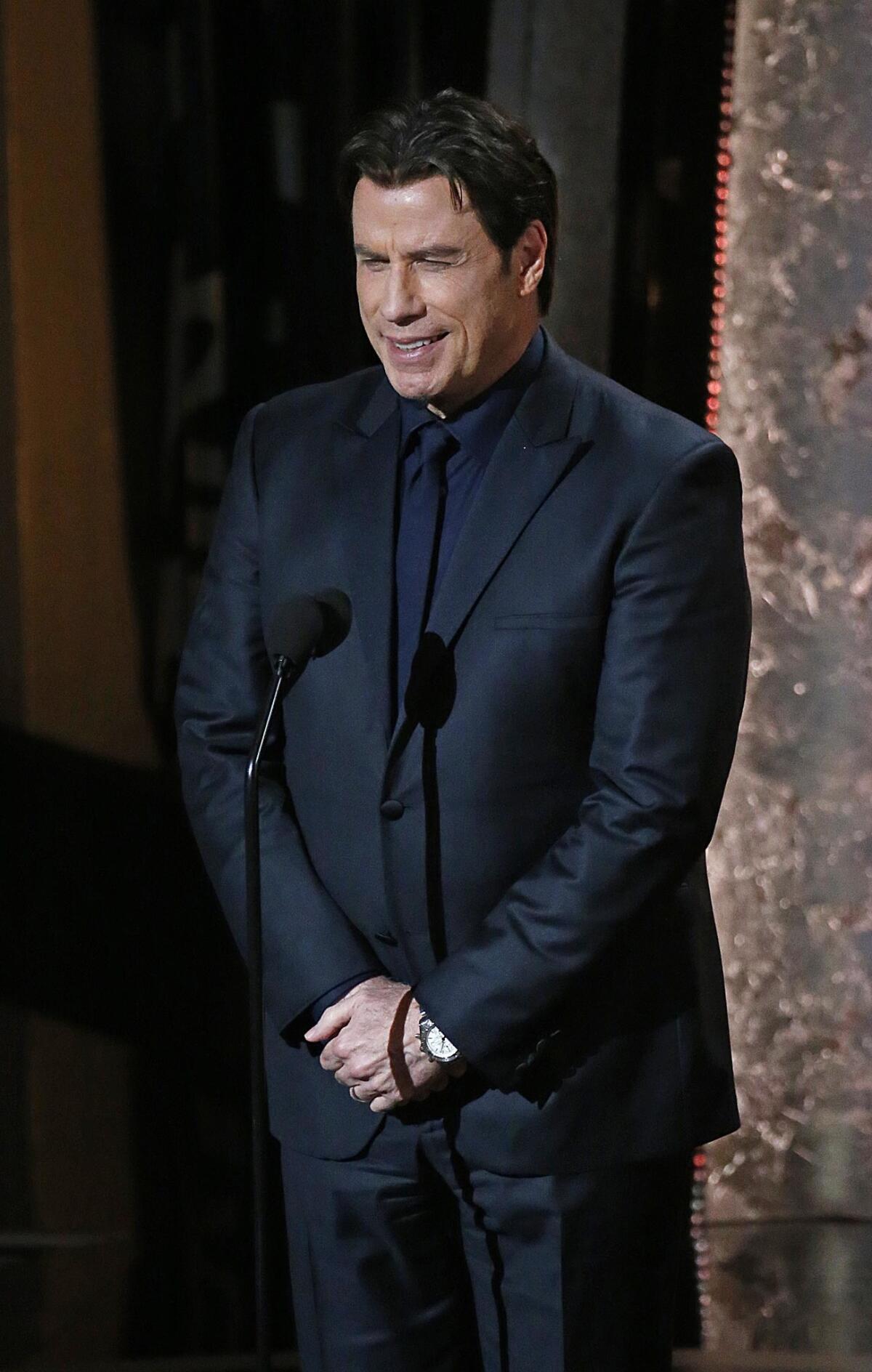 John Travolta onstage to introduce Idina Menzel (which he flubbed) during the telecast of the 86th Academy Awards.