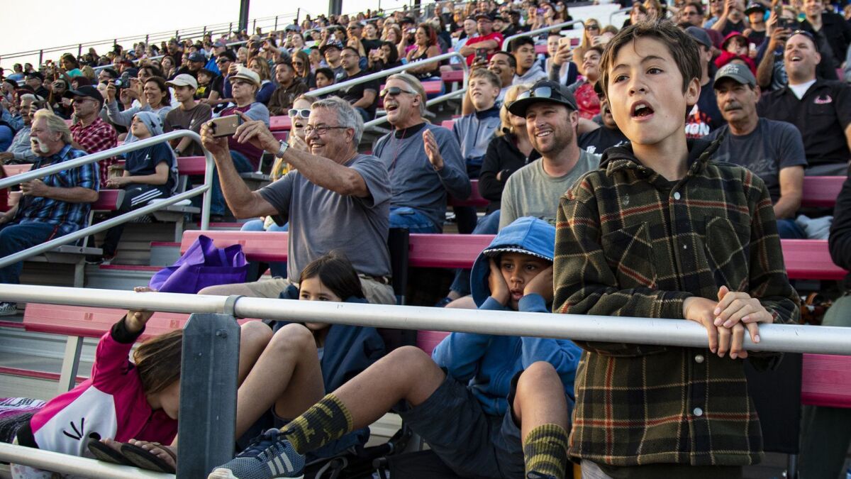 Fans react to the action on the track. Some Saturdays, Irwindale offers standard NASCAR racing. Other times, it features jumps and stunts.