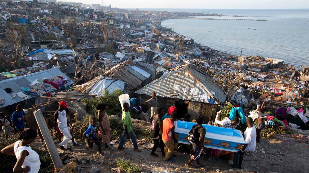 Residents carry a coffin containing the remains of a pregnant woman, a victim of Hurricane Matthew, in Jeremie, Haiti, on Oct. 7, 2016.