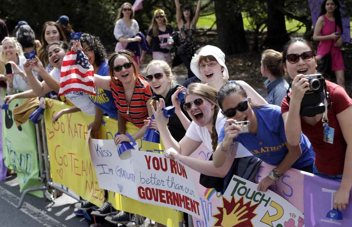 Spectators cheer near Wellesley College along the route of the 118th Boston Marathon.