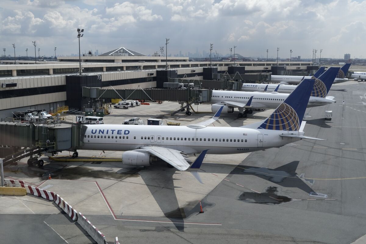 FILE - United Airlines planes are parked at gates at Newark Liberty International Airport in Newark, N.J., on July 1, 2020. United Airlines lost $646 million in the fourth quarter and said Wednesday, Jan. 19, 2021, that the current spike in COVID-19 cases will hurt its results in the March quarter. (AP Photo/Seth Wenig, File)