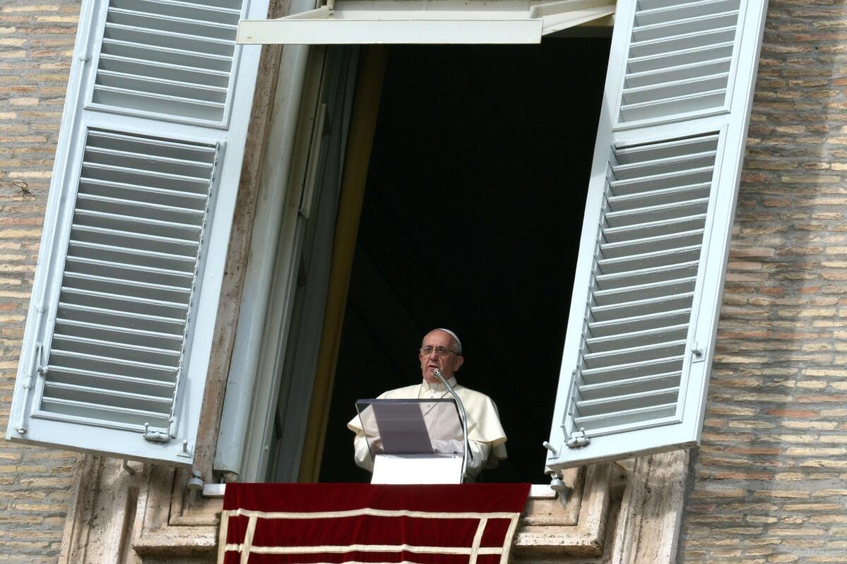 Pope Francis speaks from the window of the apostolic palace overlooking St. Peter's square during his Sunday Angelus prayer at the Vatican.