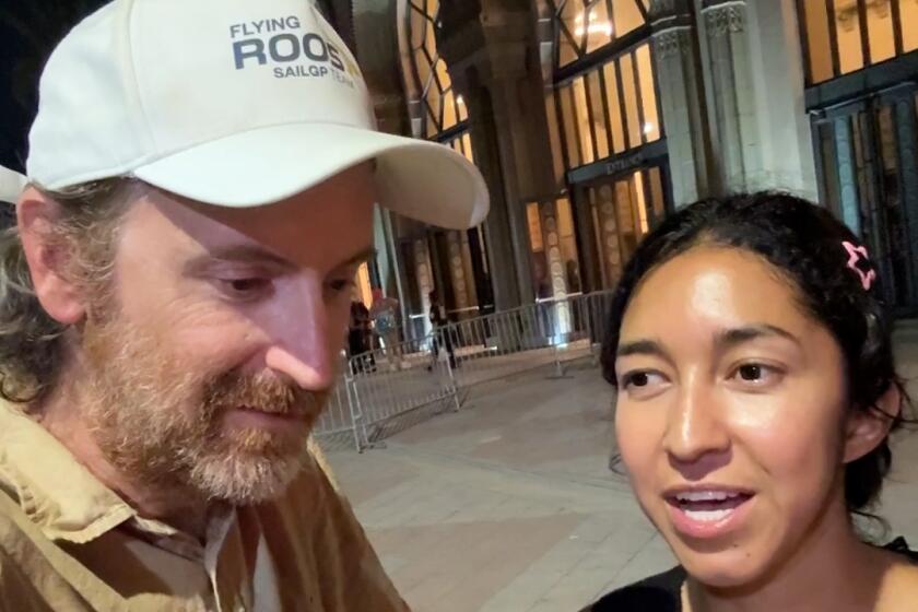 A man and woman outside of the Shrine Auditorium.