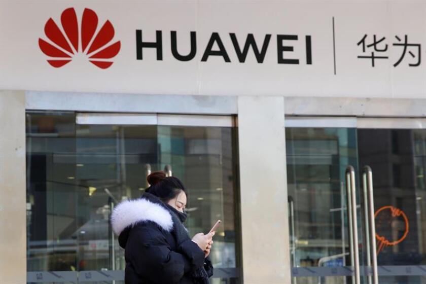 Una joven utiliza su teléfono móvil ante una tienda dela firma china Huawei en Pekín, China, el pasado 12 de diciembre de 2018. EFE/Archivo